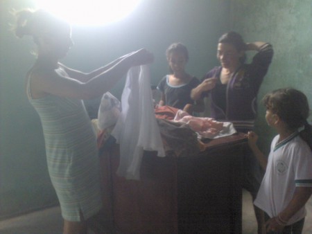 A mãe escolhendo roupinhas para as filhas